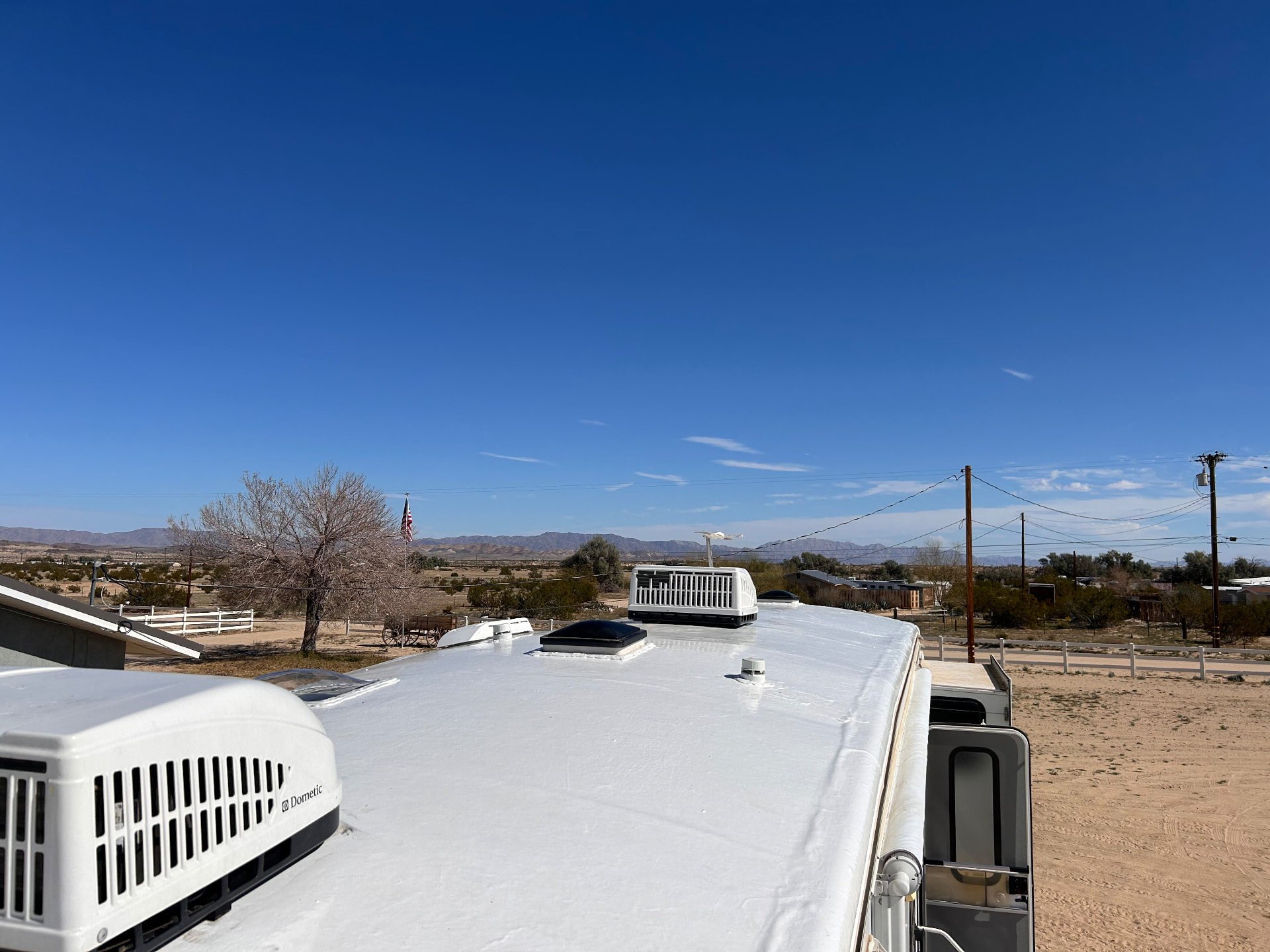 Restored white RV roof with air conditioner units in the high desert
