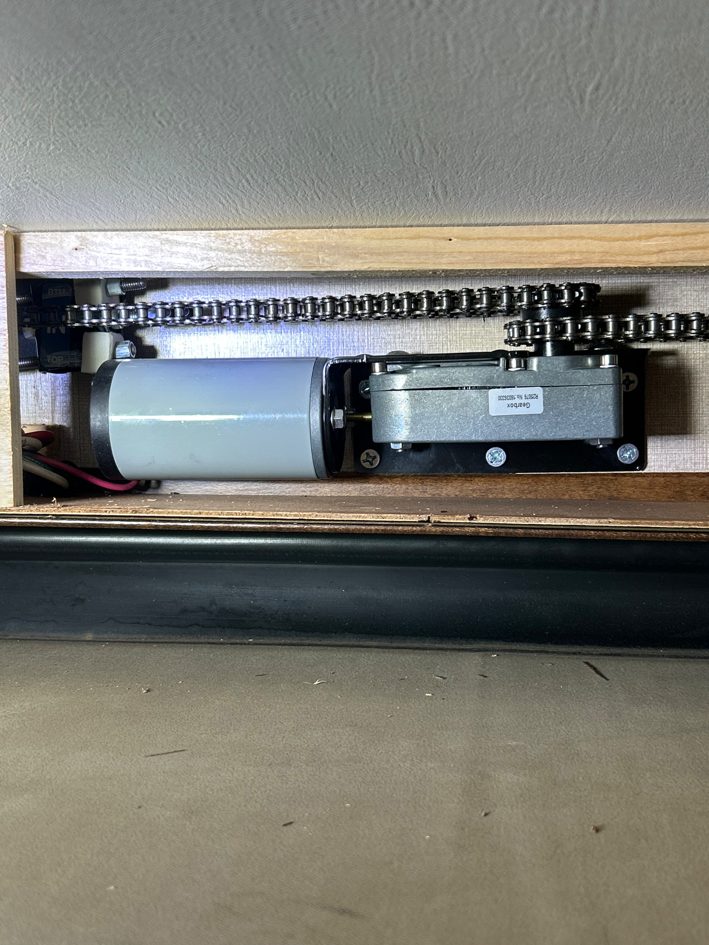RV slide-out motor and chain assembly being inspected